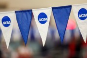 Blue and white NCAA-branded banners hang at a swim meet.