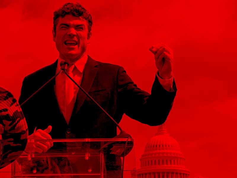 Figure with raised fist in front of a podium with exterior of US Capitol dome in background highlighted by bright color.