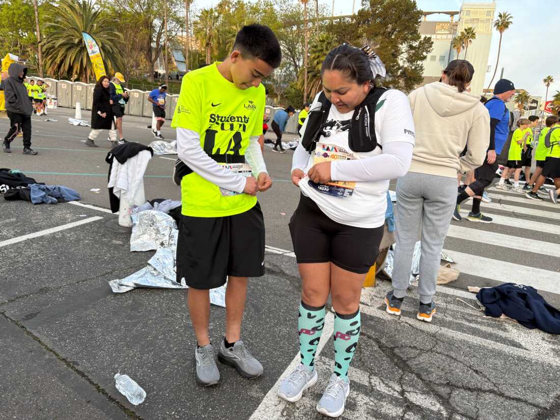 Abel Rivera and his mother, Lupe Melchor, pin on their race bibs at Dodger Stadium, the starting point of the 26.2 mile LA Marathon.