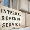 This photo shows a close-up of an exterior wall of the IRS building in Washington, D.C. Affixed on one part of the wall are black capital letters that say "Internal Revenue Service."