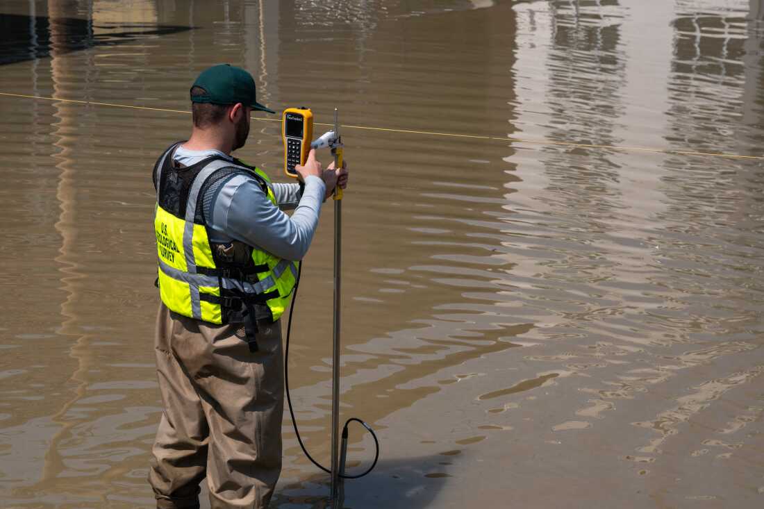 U.S. Geological Survey hydrographer Samuel Jacob measures the flooded Winooski River's discharge on July 11, 2023, in Montpelier, Vt.