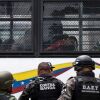 Members of the Bolivarian National Guard (GNB) stand guard as inmates aboard a bus are transferred outside the Tocoron prison in Tocoron, Aragua State, Venezuela, on September 20, 2023. (Photo by YURI CORTEZ/AFP via Getty Images)