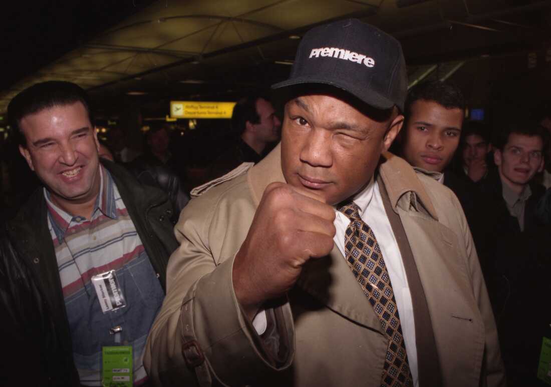 Acting heavyweight world champion George Foreman gimmicks with a playful punch closing an eye, as he arrives at the airport in Hamburg, Germany, on February 7, 1995.