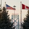 Canadian and American flags fly on the Canadian side of the Ambassador Bridge in Windsor, Ontario, on March 8. President Trump imposed vast tariffs this week on key partners Canada and Mexico, roiling cross-border ties before offering temporary relief to manufacturers -- but with more levies kicking in next week, the respite may be fleeting. 