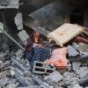 A woman cries while sitting on the rubble of her house, destroyed in an Israeli strike, in the Nuseirat refugee camp in central Gaza Strip on Tuesday. Israel on Tuesday unleashed its most intense strikes on the Gaza Strip since a January ceasefire.